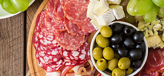 Antipasto catering platter with bacon, jerky, salami, cheese and grapes